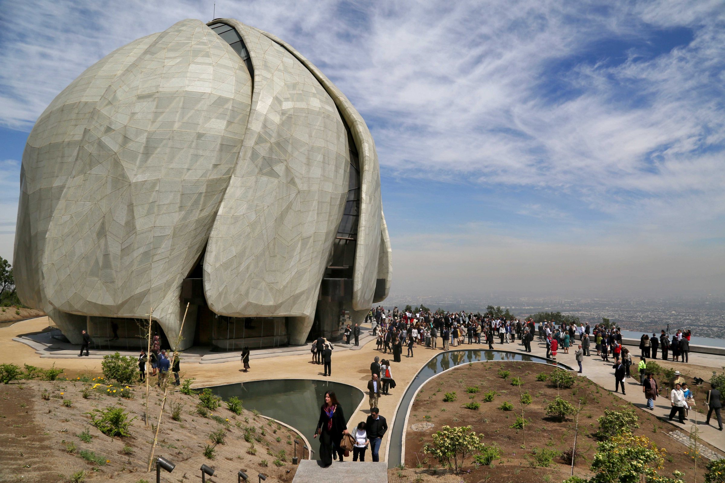 Visitantes suben la escalinata hacia el Templo Bahá’í con la cordillera de fondo